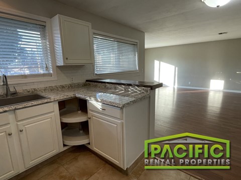 A kitchen with a countertop and cabinets is shown in a well-lit room.
