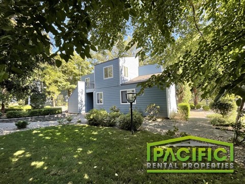 A house with a sign that says Pacific Rental Properties in front of it.
