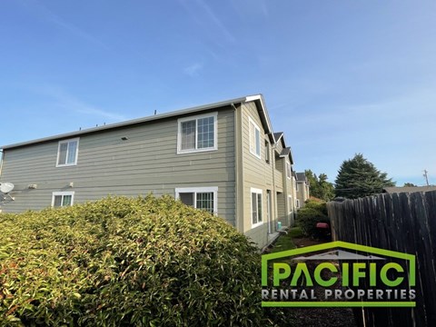 A row of houses with a sign that says Pacific Rental Properties.