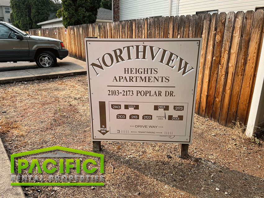 a sign for northern heights apartments in front of a wooden fence