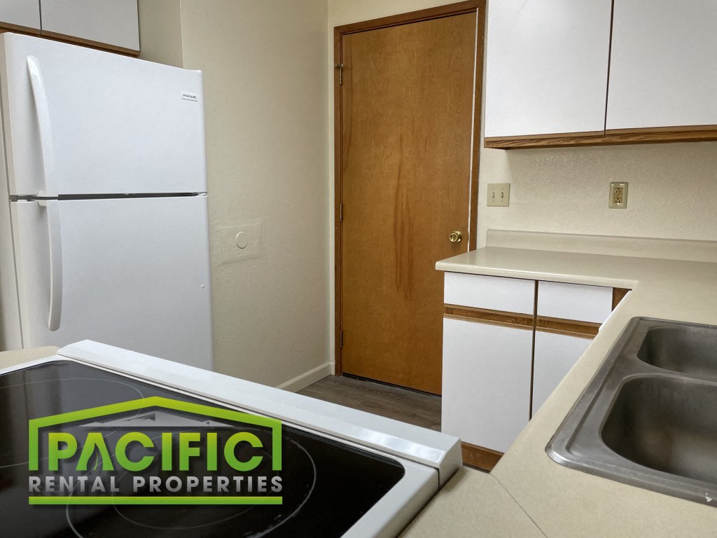 a small kitchen with a sink and a refrigerator