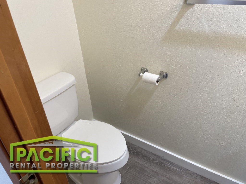 a bathroom with a toilet and a roll of toilet paper