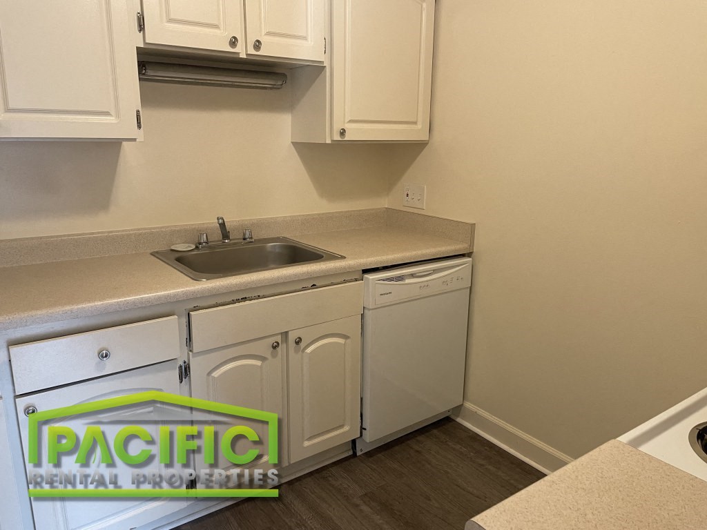 a kitchen with white cabinets and a sink