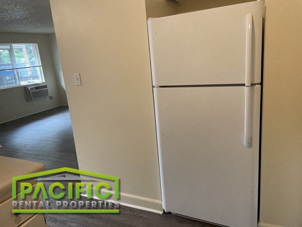 a white refrigerator freezer sitting in a room next to a doorway