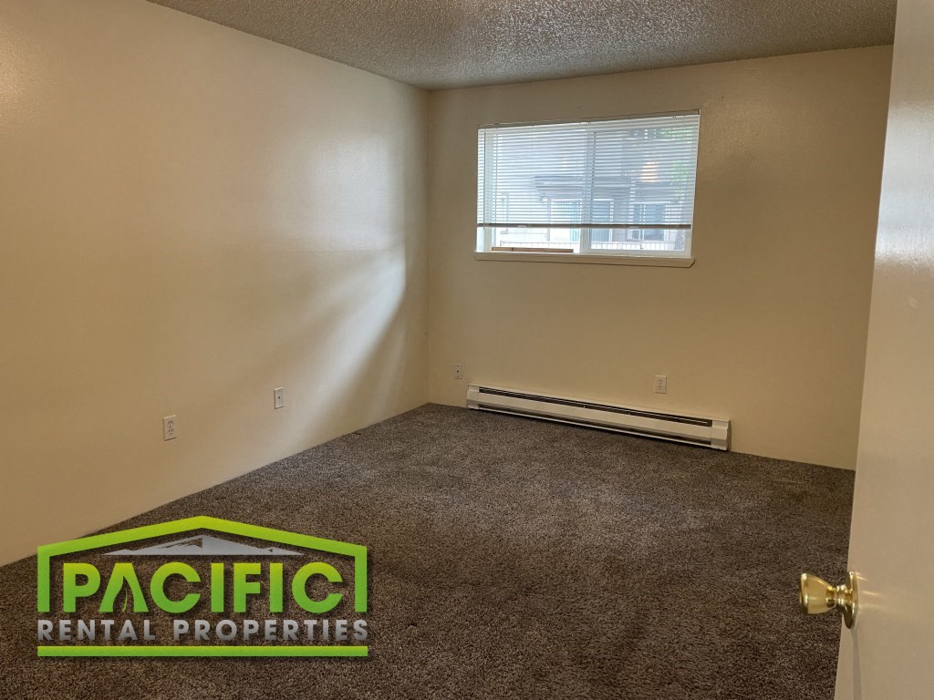 the interior of an empty room with carpet and a window