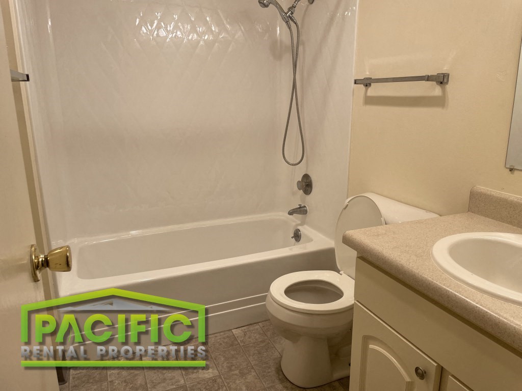 a bathroom with a toilet and a tub and a sink