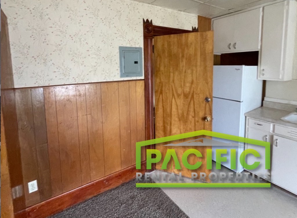 a kitchen with wood paneling and a wooden door
