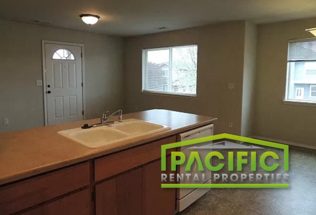 an empty kitchen with a sink and a window