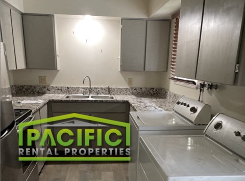 a renovated kitchen with white cabinets and granite counter tops