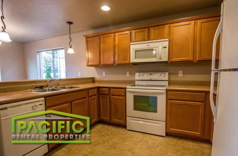 a kitchen with white appliances and wooden cabinets