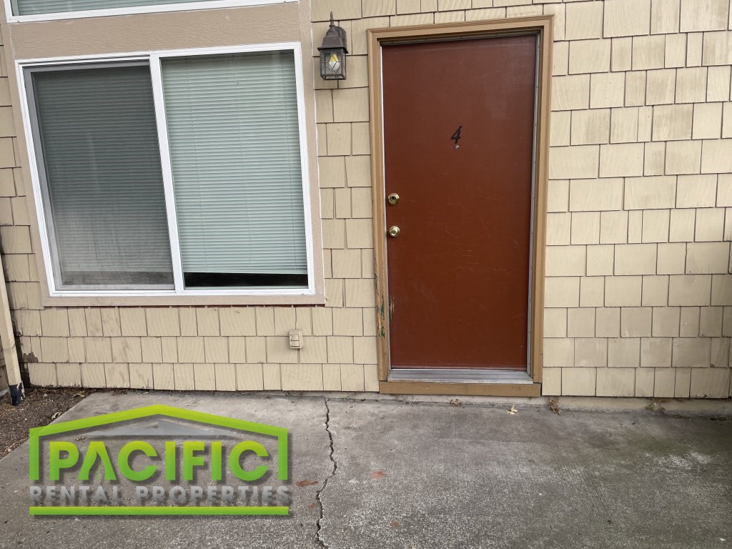 the front of a building with a brown door and a window