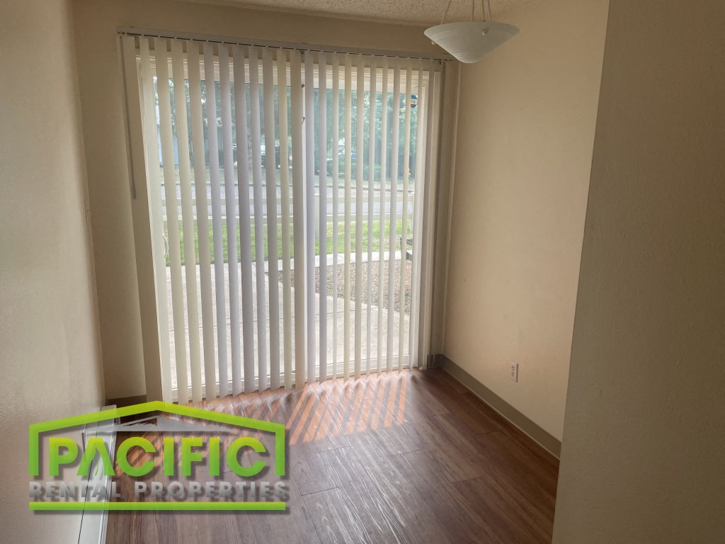 a living room with a sliding glass door and wood floors