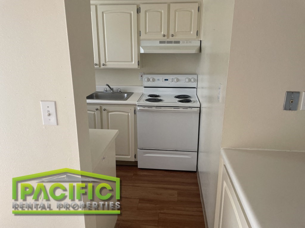 a kitchen with white appliances and white cabinets