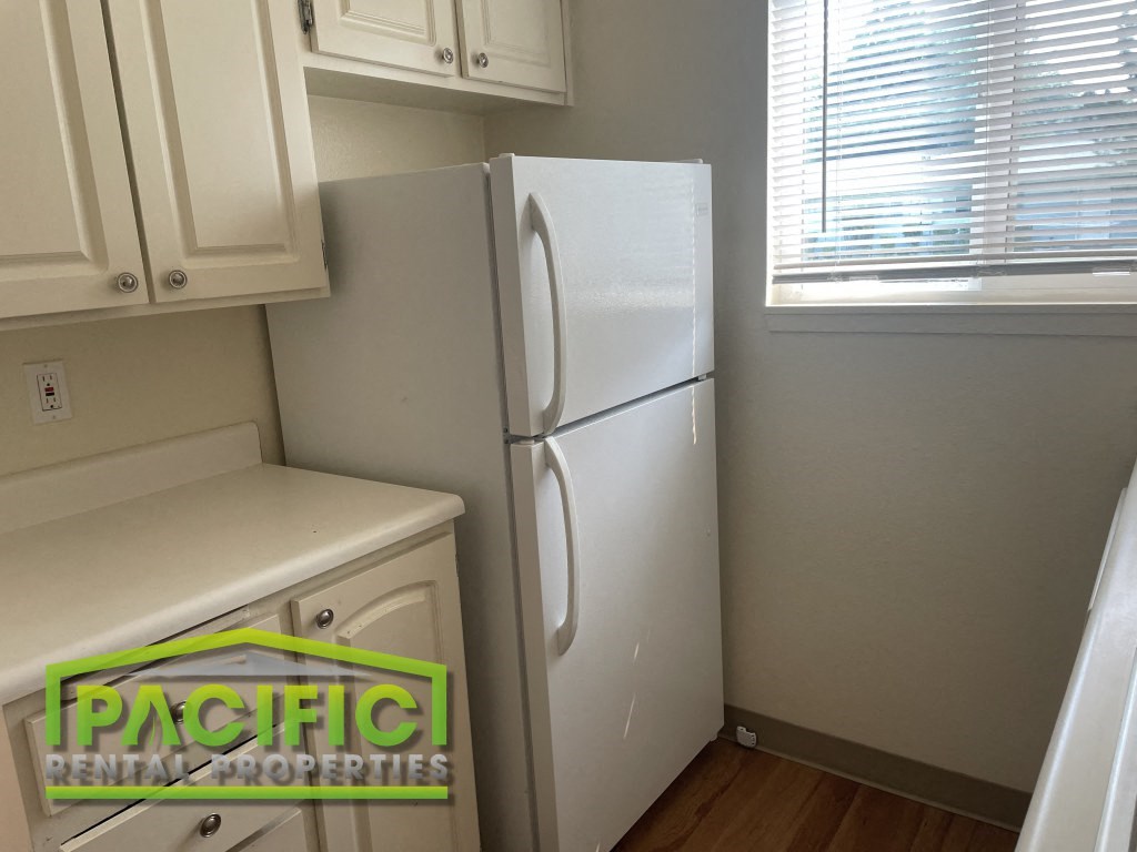 a small kitchen with a refrigerator and a window