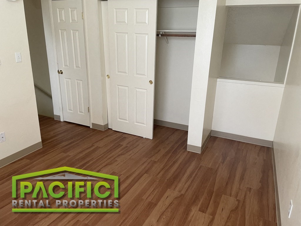 a renovated living room with wooden floors and a closet