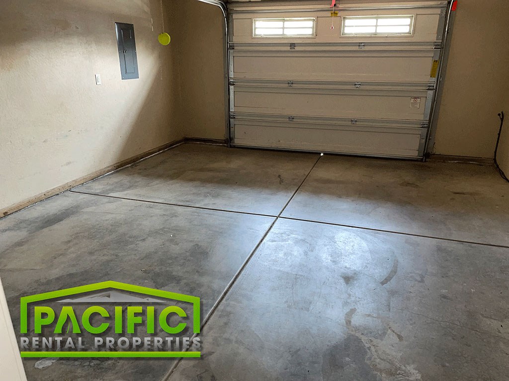 a garage with two closed doors and a concrete floor