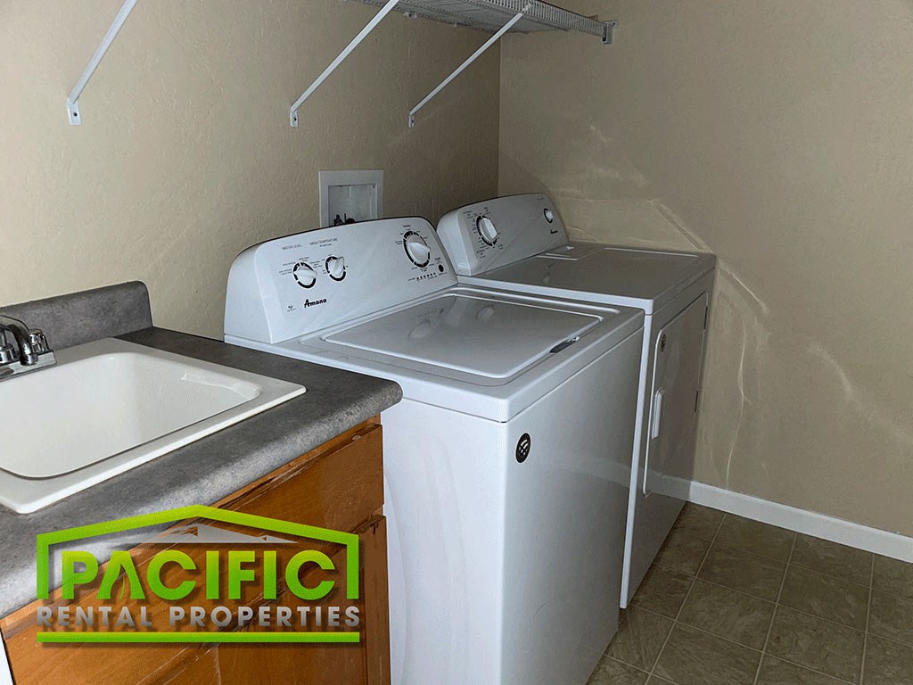 a washer and dryer in a laundry room with a sink