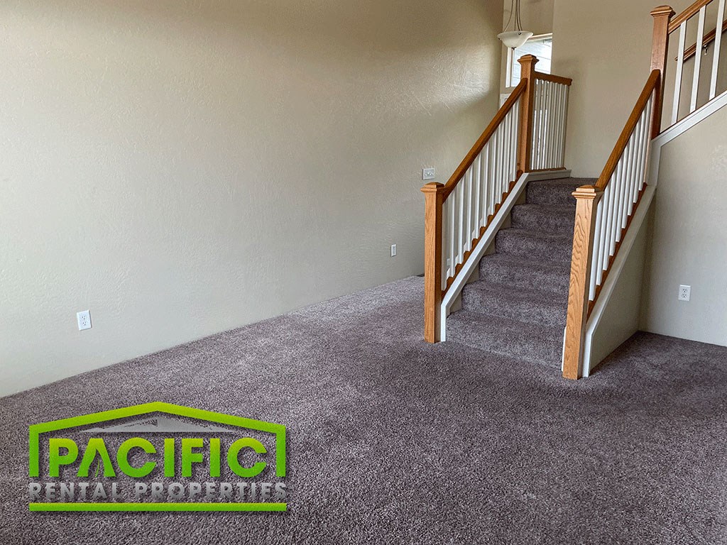 a carpeted staircase in a house with a carpet logo on the floor