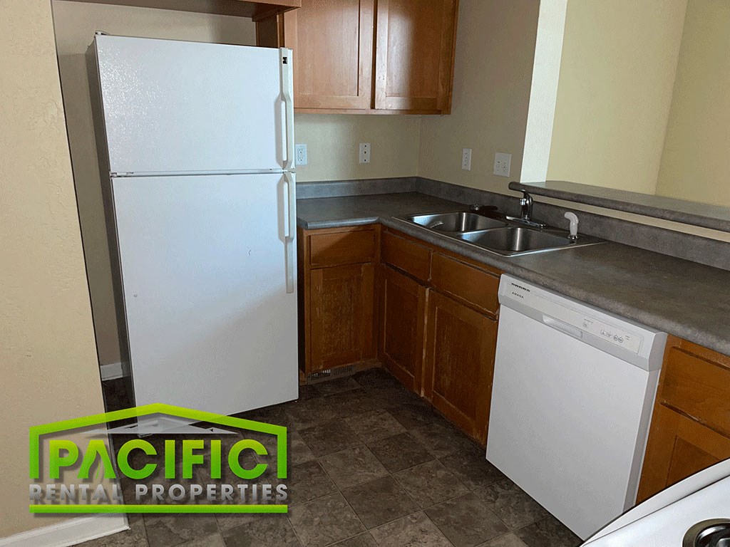 a small kitchen with a white refrigerator and a sink