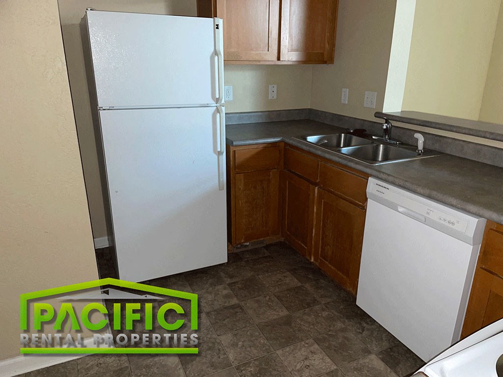 a small kitchen with a white refrigerator and a sink