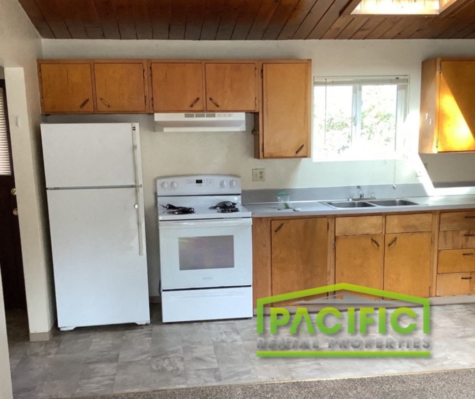 a kitchen with white appliances and wooden cabinets