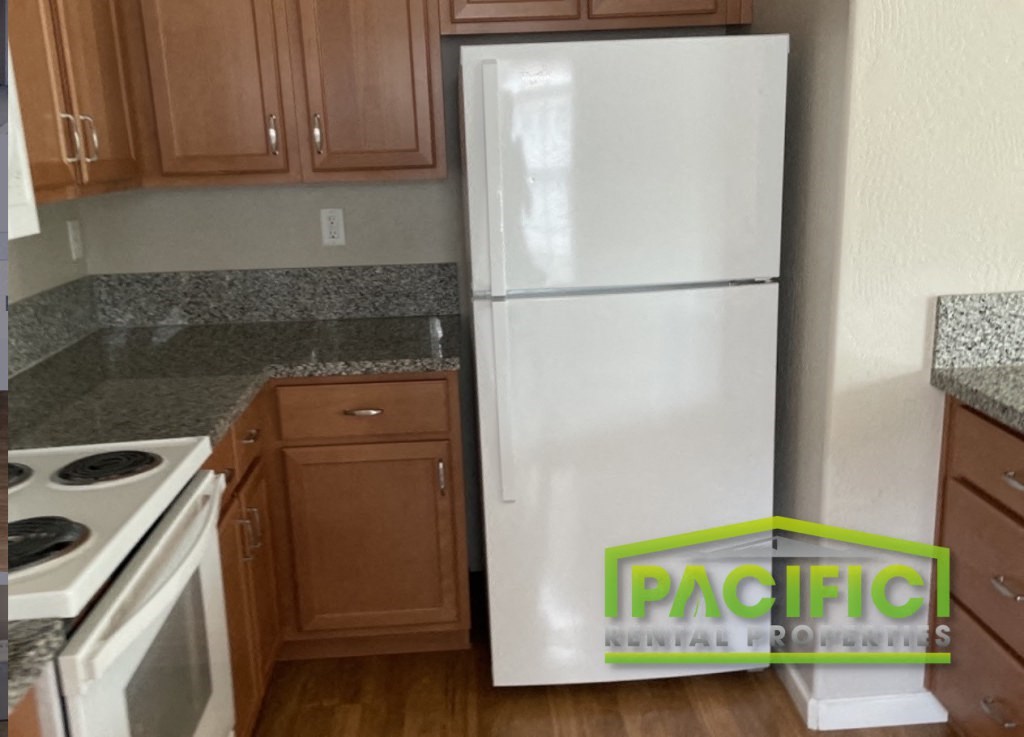 a kitchen with a white refrigerator and a counter top and a stove