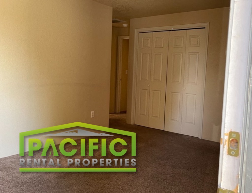 a carpeted hallway with a door and a pacific dental properties logo in the