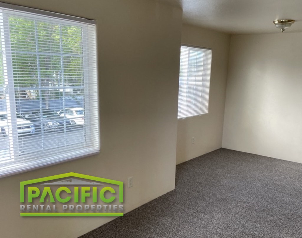 the interior of an empty living room with a window and a pacific dental props