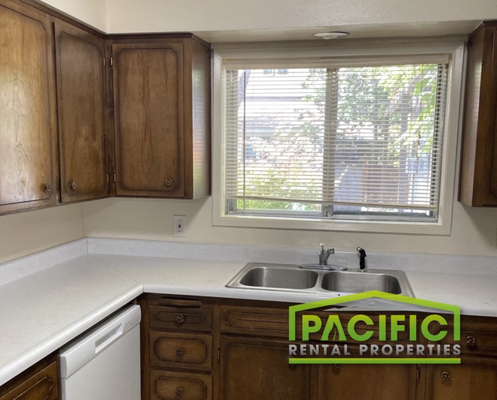an empty kitchen with a sink and a window