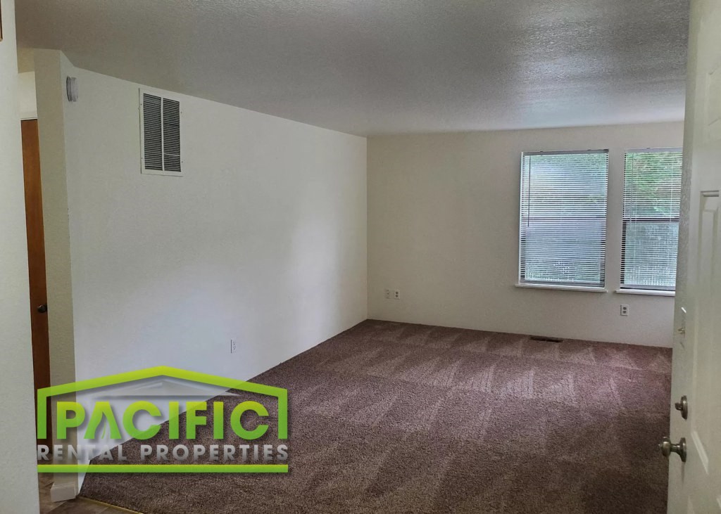the living room of a home with carpet and a window