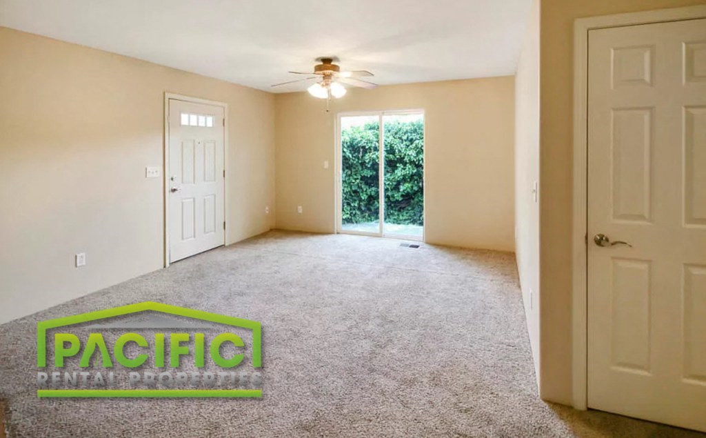 a empty living room with a ceiling fan