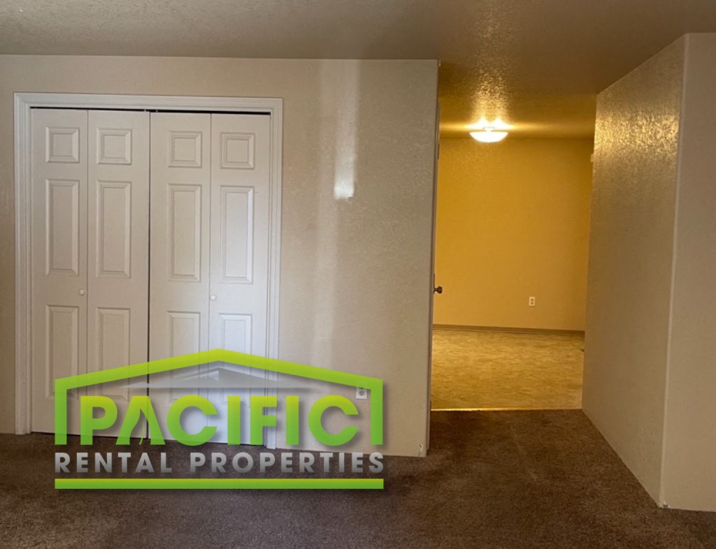 a living room with a white door and a landlord rental properties logo