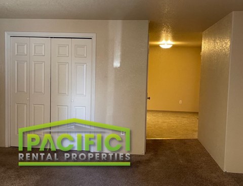 a living room with a white door and a landlord rental properties logo