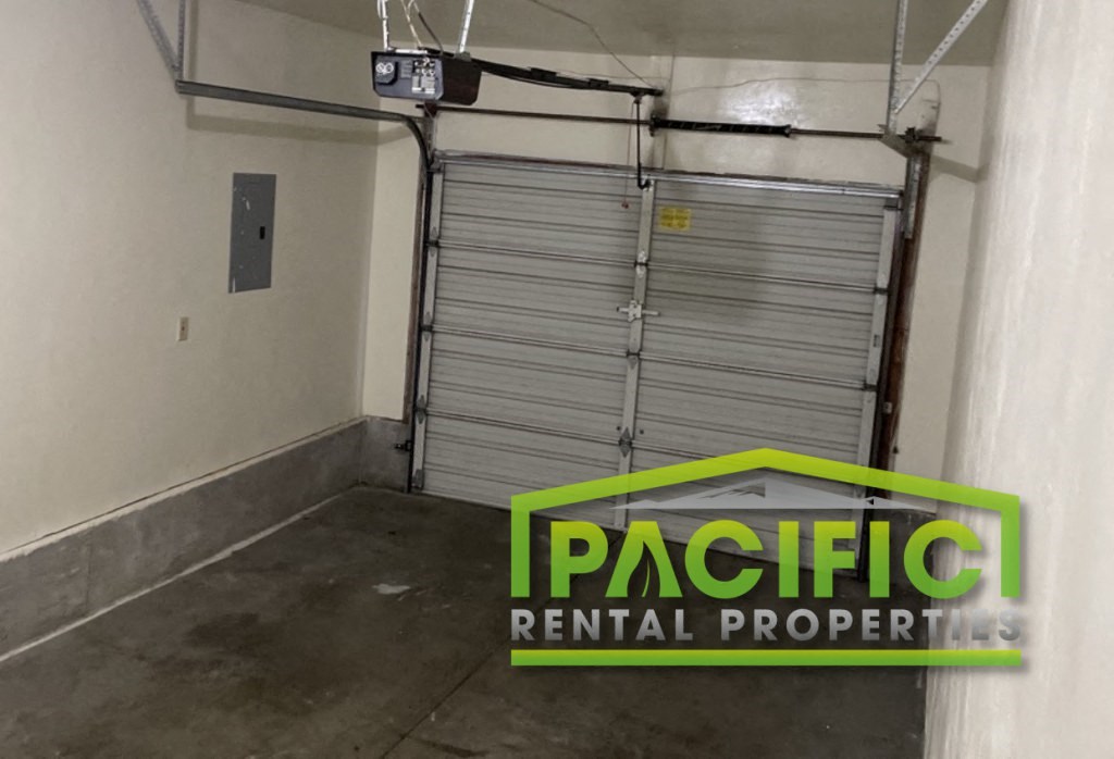 a garage door in a building with a pacific rental property logo