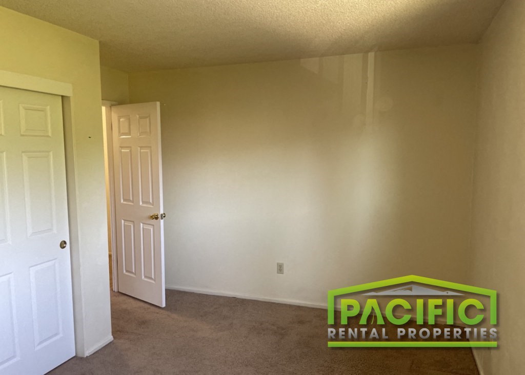 the living room of an empty house with a white door