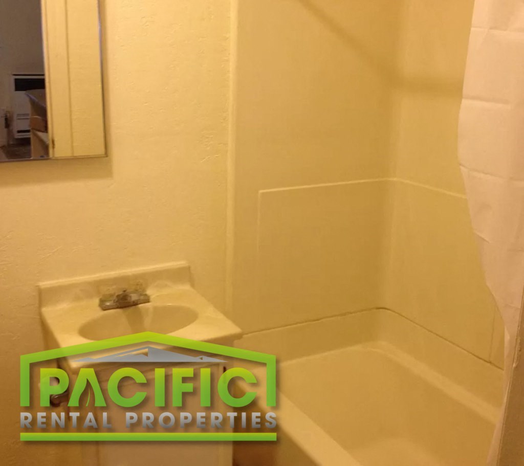 a small bathroom with a toilet and a pacific dental properties sign