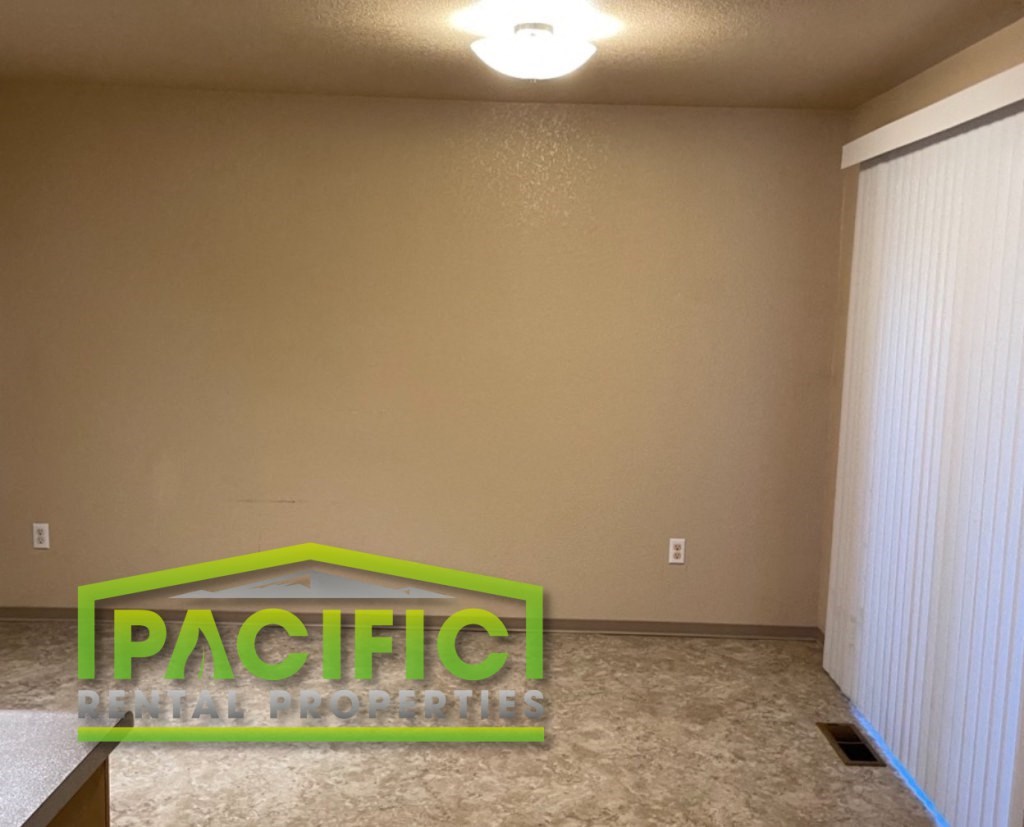 an empty living room with a sign on the floor