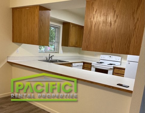a kitchen with a white counter top and wooden cabinets