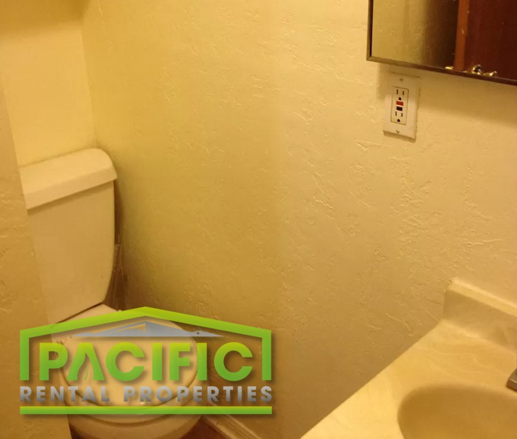 a bathroom with a toilet and a sticker on the wall