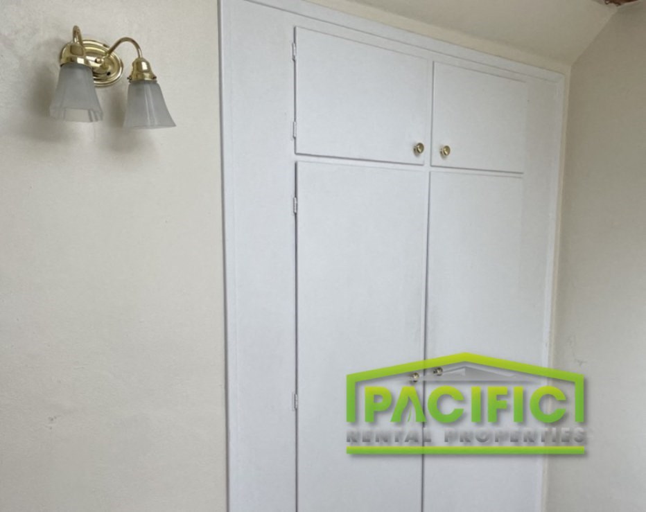 a white cabinet with two lights and a sign on the wall