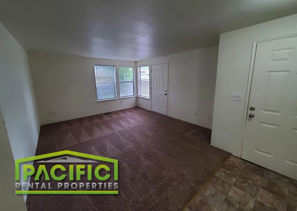 the living room of an empty house with a wooden floor