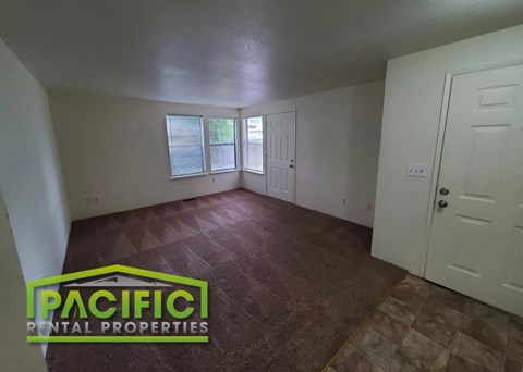 the living room of an empty house with a wooden floor