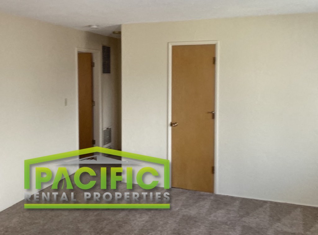 an empty room with a door and a sign on the floor