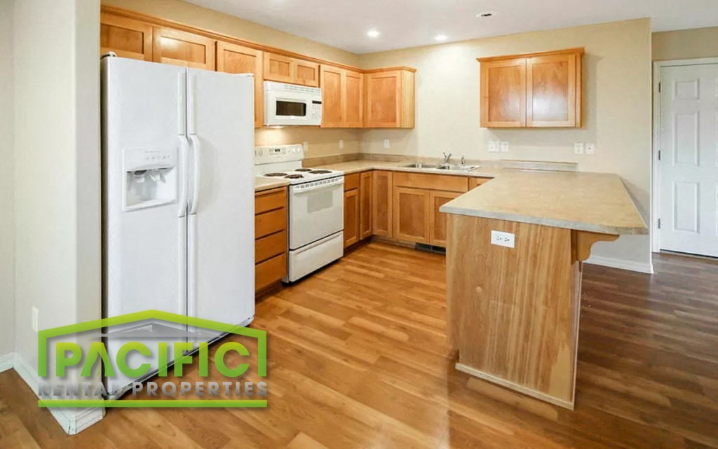 a kitchen with wooden floors and white appliances