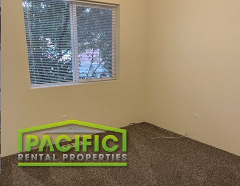 a bedroom with a window and a sign on the floor