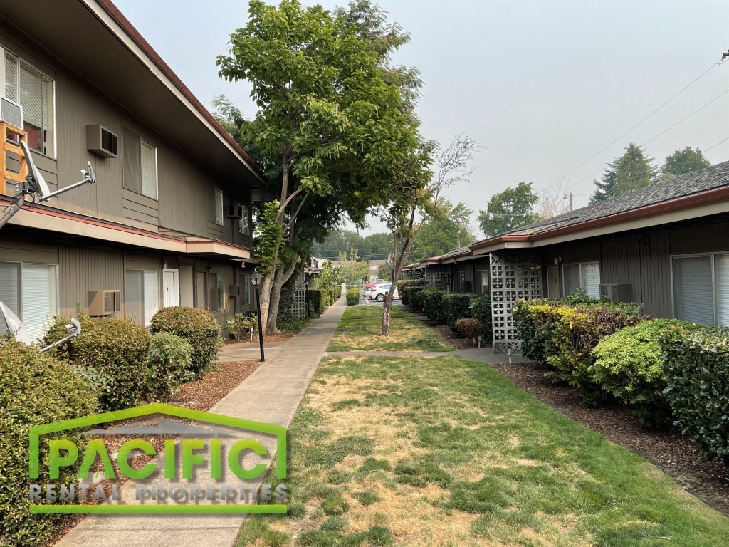 a sidewalk in front of a row of houses