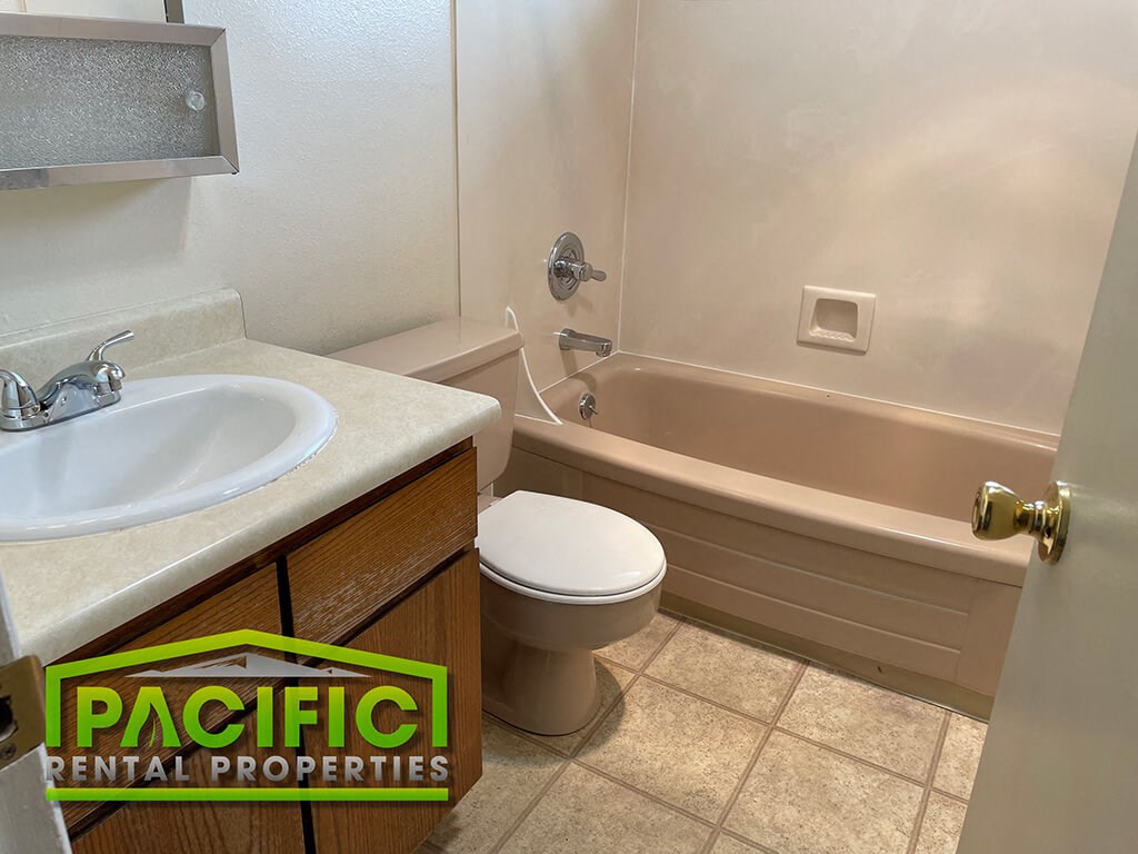 a bathroom with a toilet and a tub and a sink