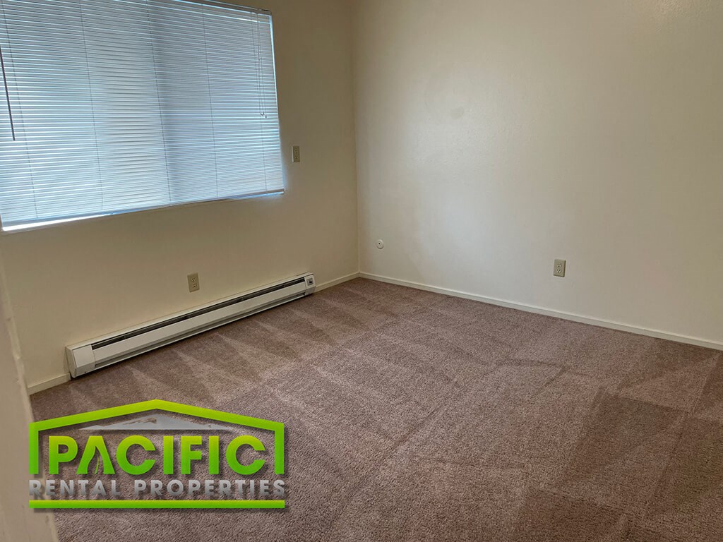 a room with a carpeted floor and a large window