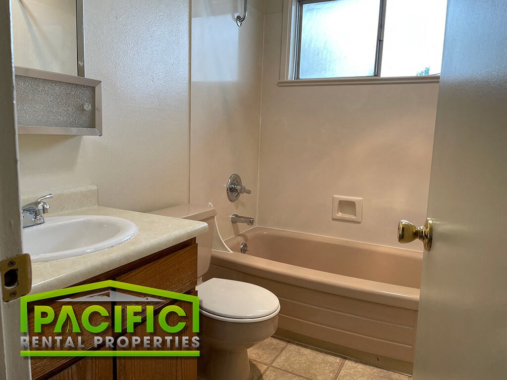 a bathroom with a toilet and a tub and a sink