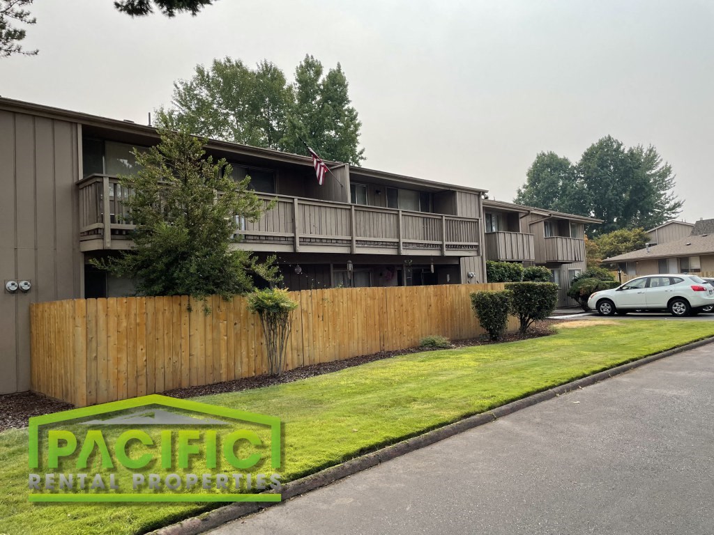 a wooden fence in front of an apartment building